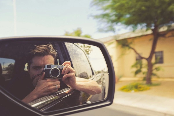 Mann fotografiert aus einem Auto andere Autos, die zu schnell fahren.